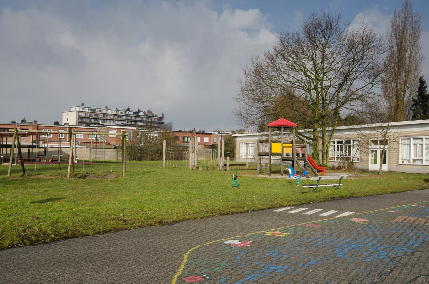 Groot grasveld met speeltuigen en schommels